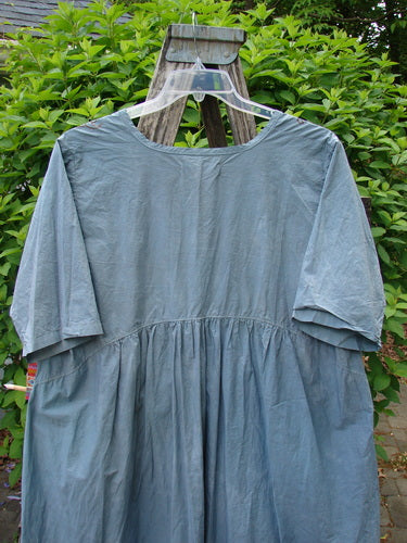 Barclay Percale Key Pocket Hi Low Dress Flower Dish Stream Size 0, featuring a gathered waist and elbow-length sleeves, is displayed on a hanger outdoors. Visible details include its knee-length design and dual drop pockets.
