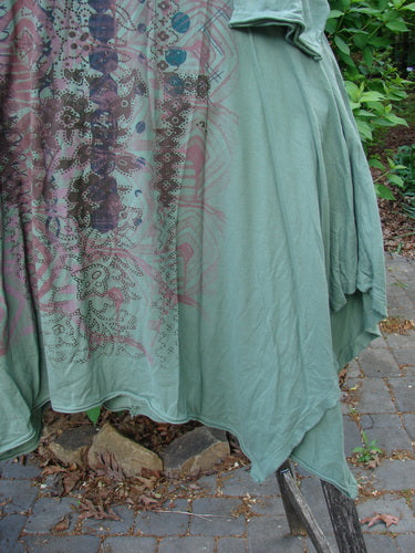 Barclay Origami Tunic Top Garden Block Spanish Moss Size 0, featuring abstract multicolor graphics, draped over a metal frame outdoors, showcasing its unique tunic length, open sides, and raw flutter edgings.