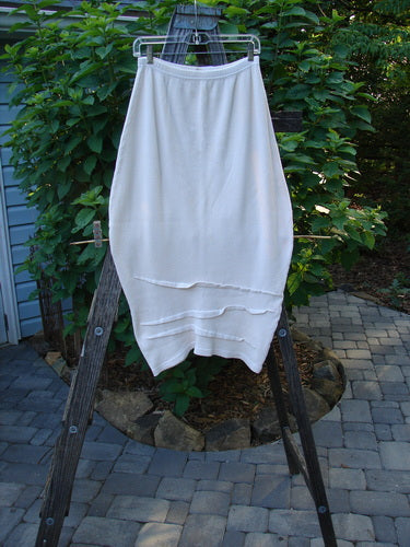 Barclay Thermal Awen Skirt Unpainted Creme Size 0 hanging on a clothesline, showcasing its unique bell shape, elastic waistband, and textured hemline.