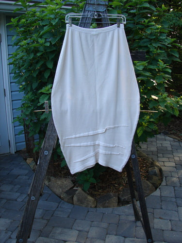 Barclay Thermal Awen Skirt Unpainted Creme Size 0, displayed hanging outdoors, highlighting its unique bell shape, textured hemline, and full elastic waistband, crafted from heavy-weight cotton thermal with Lycra.