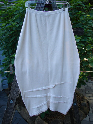 Barclay Thermal Awen Skirt Unpainted Creme Size 0 hanging on a clothesline outdoors, showcasing its unique bell shape, textured hemline, and elastic waistband.