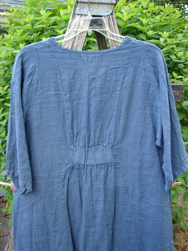 Barclay Linen Posey Dress Daisy Ray Blue Echo Size 0, featuring a flowy figure-eight shape, oval neckline, and three-quarter sleeves, displayed on a rustic ladder with greenery backdrop.