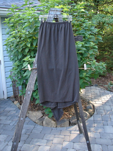 A 1994 Harvest Gather Skirt in Unpainted Bark Size 1, displayed on a wooden ladder, highlighting its unique sectional panels and adjustable lengths.