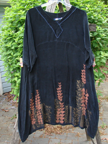Barclay Cupro Cross Over Urchin Dress in Black Evening, featuring a V-notch neckline, geometric hem, and three-quarter sleeves, in luxurious, swaying velvet-like fabric, hung against a green backdrop.