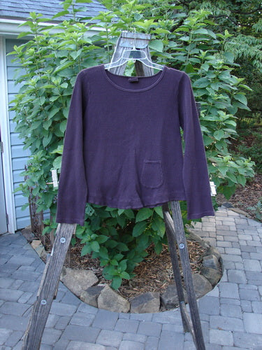 Barclay Patched Thermal Tuck Top Raisin Size 1 displayed on a wooden clothes rack, highlighting its rounded neckline, teacup patch, and longer sleeves.