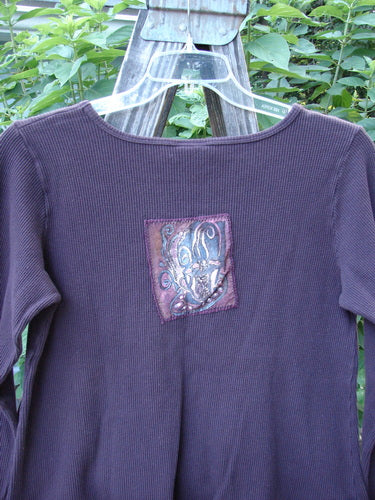 Barclay Patched Thermal Tuck Top Raisin Size 1 with a teacup patch on the rear upper center, rounded neckline, and a lower side tear-shaped pocket.