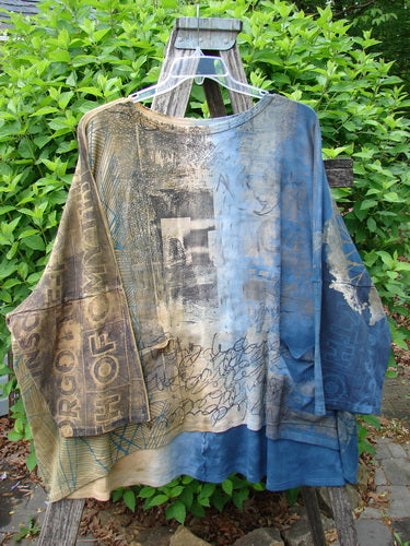 Barclay Writer's Pocket Pullover Future Night to Day OSFA displayed on a wooden stepladder, with a patchwork of abstract prints and ghosted letters, showcasing its seamless design and dual pockets.