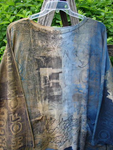 Barclay Writer's Pocket Pullover Future Night to Day OSFA features a distressed patchwork design with abstract graphics and text, displayed on a hanger outdoors, showcasing its unique artistic flair.