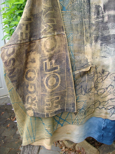 Barclay Writer's Pocket Pullover Future Night to Day OSFA, featuring a collage-style print with distressed letters and geometric patterns, draped over a wooden surface outdoors, showcasing its seamless, artistic design.