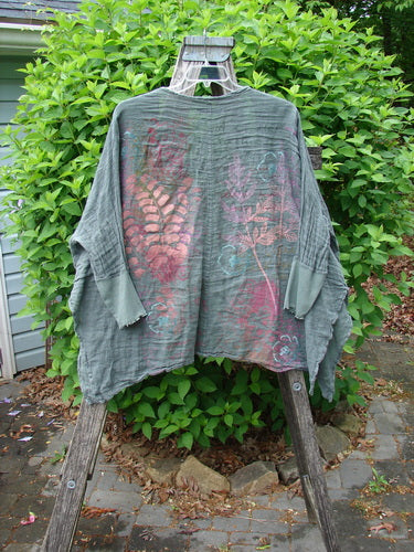 Barclay Crinkle Linen Open Front Rib Sleeve Cheerful Cardigan, featuring botanical motifs, draped over a garden ladder, showcasing dolman sleeves and vented hemline, embodying Bluefishfinder.com's creative, vintage style.