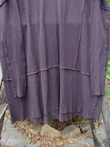 Barclay Patched Cotton Mesh Exterior Stitch Sectional Overtop Black Cherry Size 2 draped over a weathered wooden bench, showcasing its long, loose silhouette with a rounded neckline and distinctive exterior stitching.