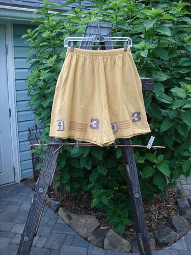 1998 8 Ball Tunic Parcheesi Short Duo Lemonade Size 0 displayed on a wooden stand. The shorts feature an elastic waistline, wide legs, and deep side pockets, showcasing a games theme paint.