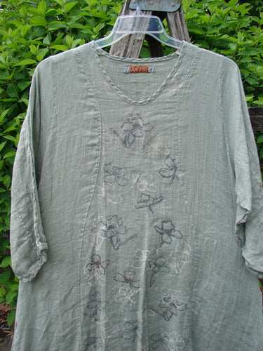 Barclay Linen High Vent Venetian Dress Contour Floral Sage Size 1 with a scooped neckline, floral embroidery, and three-quarter sleeves, showcased outdoors on a hanger with leafy foliage background.