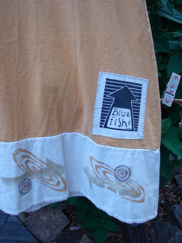 Close-up of the 1998 8 Ball Tunic Parcheesi Short Duo Lemonade Size 0, featuring the Blue Fish logo and detailed paintwork on a white cloth.