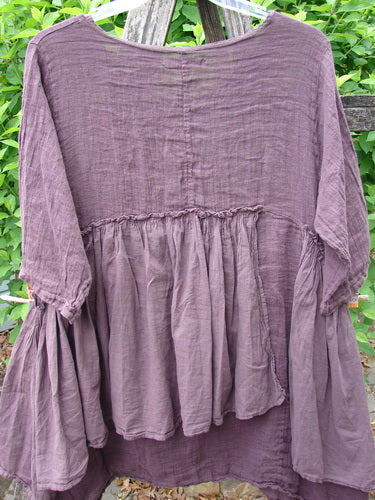 Barclay Gauze Batiste Petal Urchin Flounce Dress Unpainted Fig Size 1 hangs outdoors, showcasing its loose-fitting, tiered design with raglan sleeves and gathered accents, reflecting Bluefishfinder.com's vintage-inspired ethos.