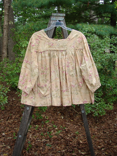 Magnolia Pearl Embroidered Light Weight Cotton Prairie Pocket Top Vintage Rose OSFA on a wooden stand, showcasing square neckline, flowing A-line shape, embroidery accents, and a sweeping design.