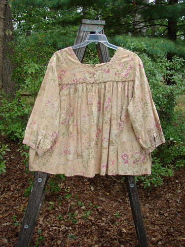 Magnolia Pearl Embroidered Light Weight Cotton Prairie Pocket Top Vintage Rose OSFA displayed on a wooden stand, highlighting its square neckline, vertical panel, and flowing A-line shape with embroidery accents.