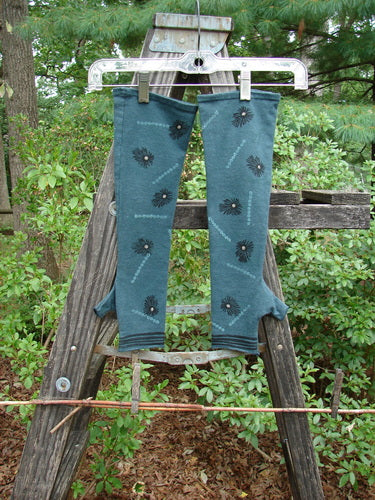 Barclay Cotton Lycra Hemp Fingerless Glove Polka Flower Blue Grey OSFA displayed on a wooden fence, showcasing its flattened edgings, four-finger opening, thumb tunnel, and polka flower theme.