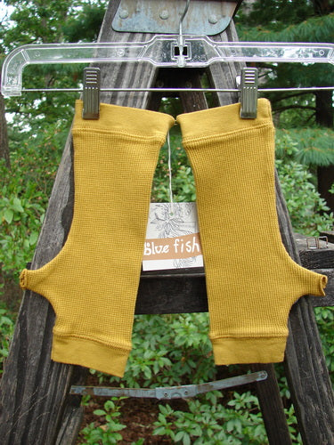 Barclay NWT Thermal Banded Fingerless Wrist Glove Unpainted Mustard One Size, hanging on a clothesline, showcasing its cozy cotton waffle thermal texture and four-finger top opening with thumbholes.