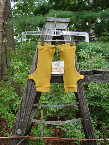 Barclay NWT Thermal Banded Fingerless Wrist Glove Unpainted Mustard One Size, displayed draped over a wooden ladder, showcasing banded thermal edgings and cozy cotton waffle texture.