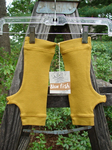 Barclay NWT Thermal Banded Fingerless Wrist Glove Unpainted Mustard One Size hanging on a clothesline, displaying banded thermal edgings, four-finger top opening, and thumbholes.