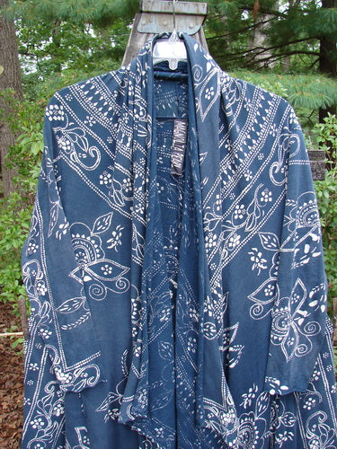 Magnolia Pearl Cotton Jersey Kareas Cardigan Jacket Navy Ranch Hand OSFA displayed on an outdoor swing, showcasing its knot-able hemline, A-line shape, open front, and distinctive bandana print.