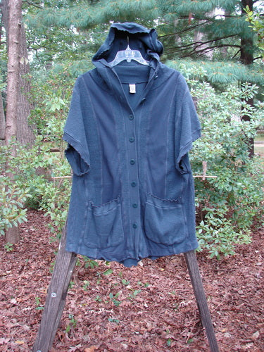 Barclay Celtic Moss Hooded Pocket Cardigan Unpainted Navy Storm Size 0 displayed outdoors on a hanger, featuring a floppy hood, short sleeves, two exterior pockets, curly edges, and a full button front.