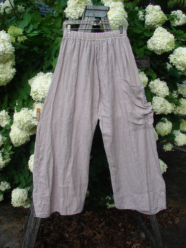 Bluefishfinder.com Barclay Linen Single Side Pocket Banded Bottom Pant in unpainted mallow, size 0, shown as loose, wide-leg pants with a gathered waistband and a single side pocket. The soft linen fabric has a muted gray-lavender tone and a lightly wrinkled texture.