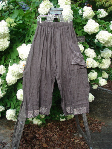 Susan Crawford Barclay Linen Single Crop Side Pocket Banded Bottom Pant in Celtic Floral Mocha, size 2, shown hanging outdoors with a floral hem and side pocket detail.