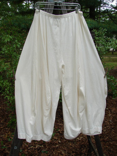 Barclay 4 Square Pant Unpainted Summer Natural Size 2, hanging on a rope outdoors, showcasing its unique 3D diamond cut from the knee down and pocketless sway in lightweight organic cotton.