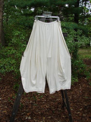 Barclay 4 Square Pant Unpainted Summer Natural Size 2, displayed on a rack, showcasing its unique 3D diamond cut from the knee down, made from lightweight organic cotton.