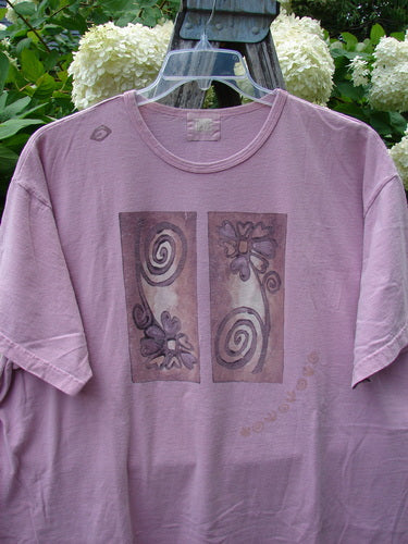 Bluefishfinder.com 1999 Short Sleeved Tee Double Daisy Peony Size 2 in dusty mauve cotton, with a relaxed crew neck and short sleeves. The front shows two vertical floral panels with spiral motifs, hanging outdoors against green foliage and white blooms.