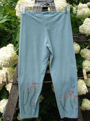 Bluefishfinder.com Barclay Cotton Lycra Crop Legging Rising Floral Sky Size 0 in pale blue cotton-lycra, shown front-facing on a hanger. Delicate rising floral graphics near the lower legs and a slim cropped silhouette stand out against the soft matte fabric.