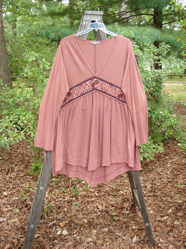 Barclay Decora Banded V Neck Dress Rouge Size 1 displayed on a wooden swing, showcasing its deep V neckline, vertical pleats, and varying hemline.