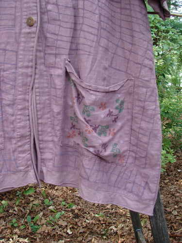 Barclay Linen Cotton Sleeve Pocket Cardigan Rich Mauve Size 0 displayed on a pole, featuring wooden button, V-neckline, drop shoulders with floral sleeves, and matching square pockets.