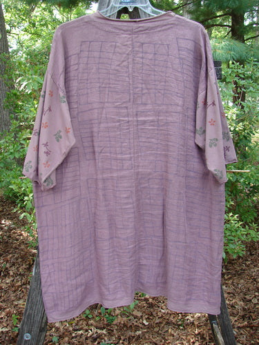 Barclay Linen Cotton Sleeve Pocket Cardigan Rich Mauve Size 0 hanging on a clothesline, showcasing its wooden button, V-shaped neckline, organic cotton floral sleeves, and drop front lower squared pockets.