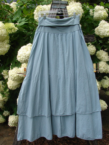 Bluefishfinder.com Barclay Batiste Fold Over Two Tier Stardust Skirt in unpainted dusky sky, size 0, shown in a soft blue-gray drape with a folded waistband and two tiered panels. The lightweight fabric hangs in gentle vertical folds with a wide, flowing hem.