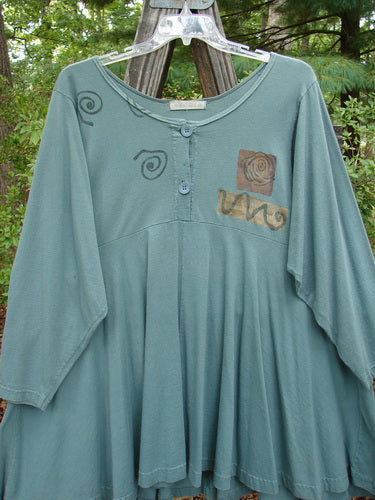 1994 Juniper Dress Swirl Leaf Sea Journey Size 2 displayed on a wooden swinger, showcasing its wider rounded collar, sectional panels, and unique vintage design with a sweeping lower hem.