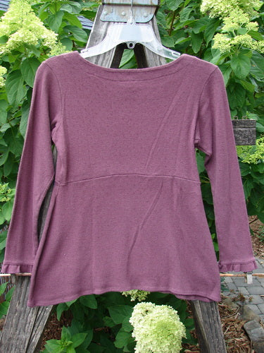 2000 Wool Pointelle Anais Top Unpainted Murple Tiny Size 0 displayed on a hanger, highlighting its fitted design, empire waist seam, and sweet lettuce edging.