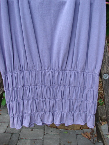 2000 NWT Rings of Saturn Skirt Unpainted Twilight Size 2 displayed draped over a wooden ladder, showcasing its full length and unique tapered, pegged lower design with detailed stretchy smocking.