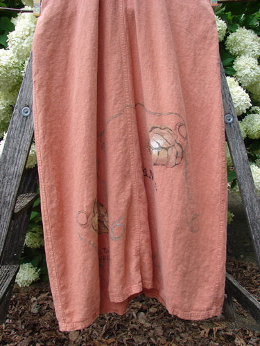 Bluefishfinder.com 1998 Botanicals Planters Overall Jumper Leaf Mimosa Size 0 in dusty rose fabric, with a loose, draped silhouette and faint botanical print. The hem falls in soft folds, framed by a rustic wooden chair and white flowers in the background.