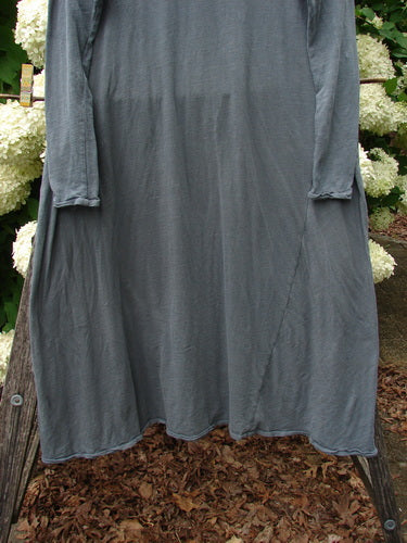 Bluefishfinder.com Magnolia Pearl Cotton Jersey Dylan Dress Fairy Ozzy OSFA in muted gray cotton jersey, shown as a loose, long-sleeved dress with a soft drape, raw-looking hem, and relaxed, oversized silhouette. It hangs centered against white hydrangeas and weathered wood, with a subdued earthy palette and natural outdoor light.