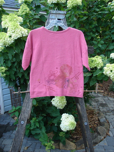 1997 Cotton Cashmere Crop Pullover Wind Flower Geranium Altered OSFA displayed on a ladder, showcasing its short sleeves, drop shoulders, thinly ribbed hemline, and detailed wind flower theme paint.