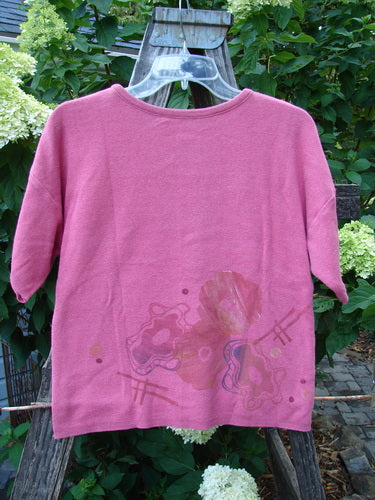 1997 Cotton Cashmere Crop Pullover Wind Flower Geranium Altered OSFA on a hanger, showcasing short sleeves, drop shoulders, ribbed hemline, and rolled neckline with detailed wind flower theme paint.