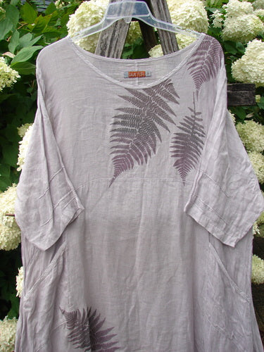 Bluefishfinder.com Barclay Linen Wave Pocket Dress in Fern Rice Paper, size 1, shown in a loose linen silhouette with a soft scoop neckline, wide short sleeves, and fern-like wave prints across the chest and hem. The pale rice-paper tone and lightly wrinkled texture give it a relaxed, airy look.