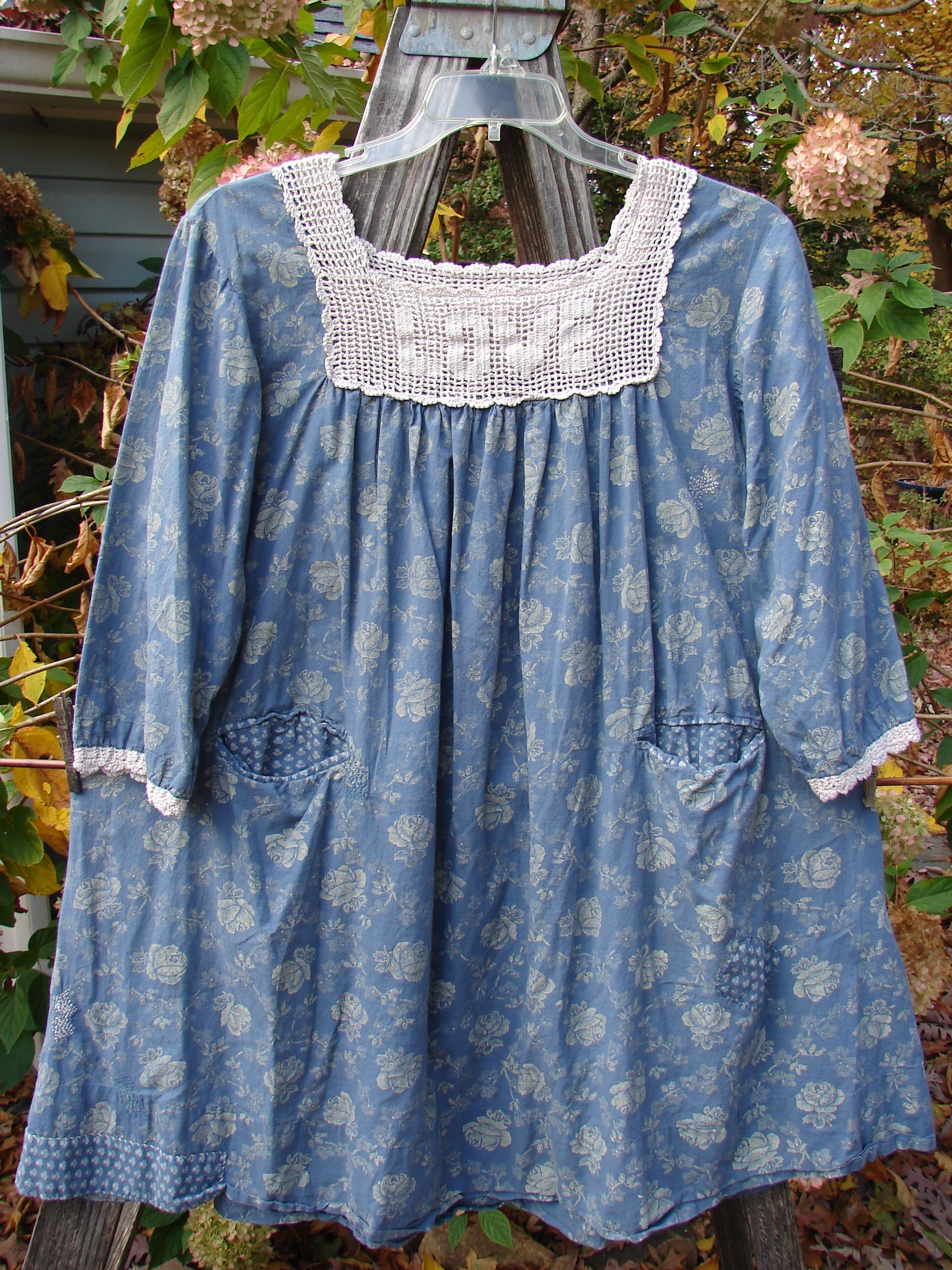 Magnolia Pearl European Cotton Crochet Love Tunic Vintage Blue Rose OSFA displayed on a hanger, showcasing its gathered crochet square top, three-quarter sleeves, and A-line shape.