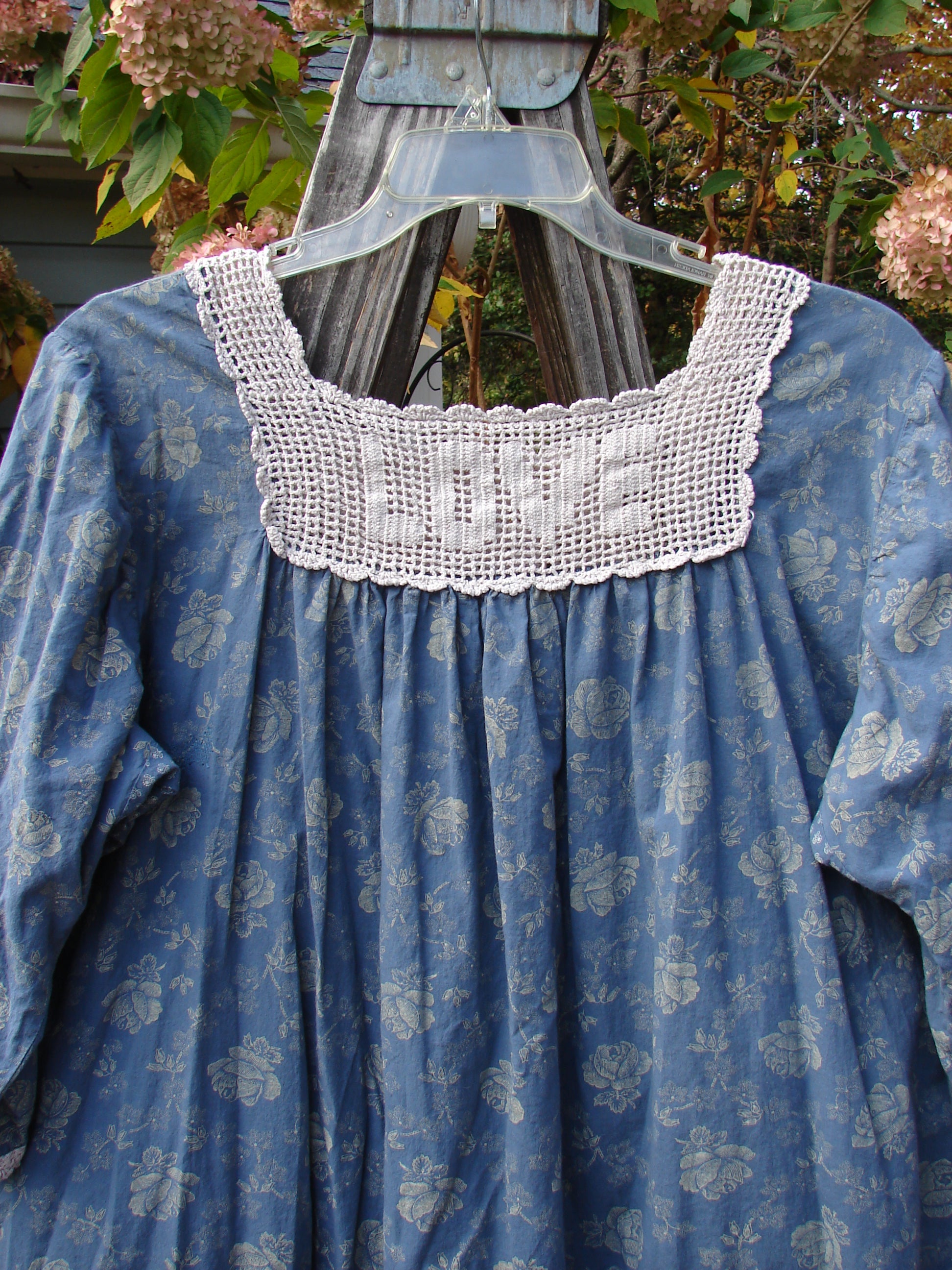 Magnolia Pearl European Cotton Crochet Love Tunic Vintage Blue Rose OSFA features white lace accents, three-quarter sleeves, and dual pockets, showcasing a vintage blue rose design with crochet detailing.