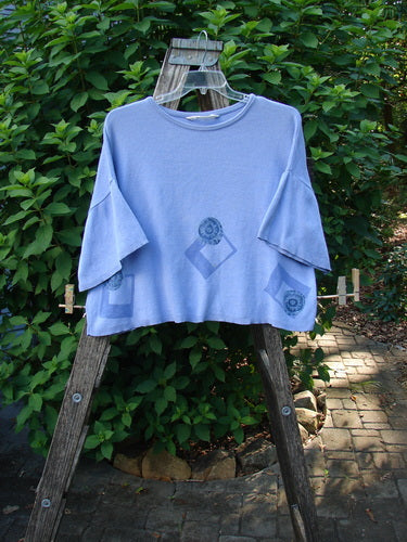 1997 Cotton Cashmere Short Sleeved Crop Pullover Geometric Skylark OSFA, with wide flared sleeves and subtle mandala print, draped on a ladder, showcasing its unique design and luxurious cotton cashmere blend.