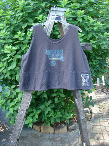 1995 Klee Top Garden Friends Shadow Size 1, featuring a cropped A-line shape with a scooped neckline, Blue Fish patch, and hand-stamped button, displayed on a wooden ladder against a garden backdrop.