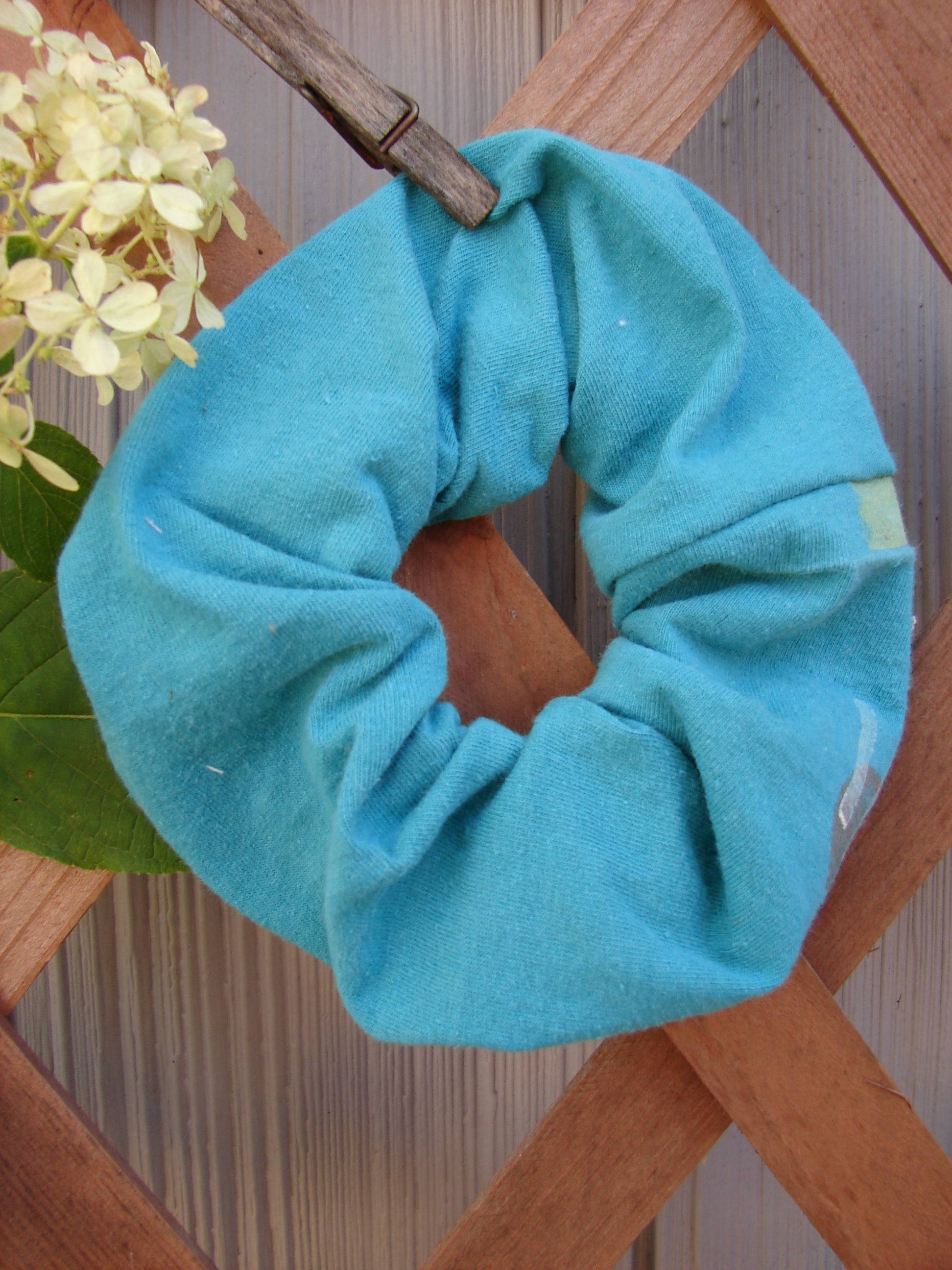 1990 PMU Cotton Hair Scrunchie Abstract Turq One Size, featuring ruffled fabric and thin elastic band, displayed on a wooden surface, highlighting its vintage-inspired design and soft texture.